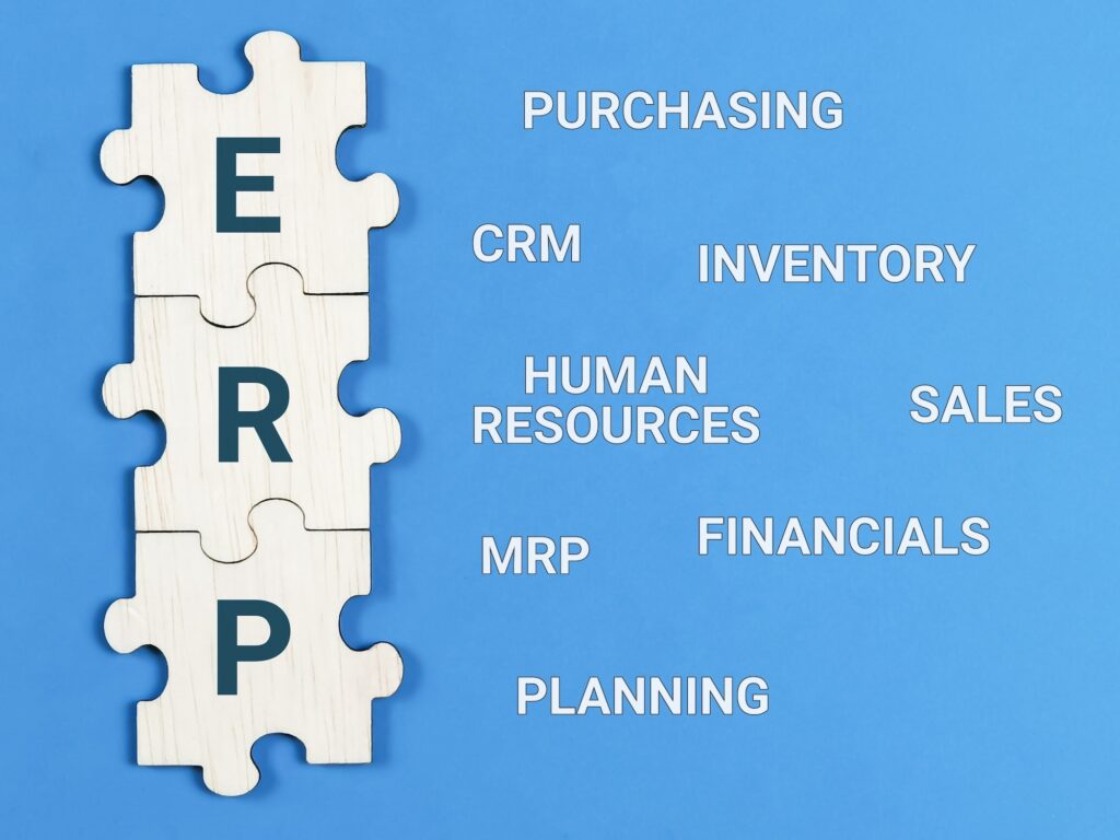 Enterprise Resource Planning concept. Text ERP with jigsaw puzzle pieces on blue background.